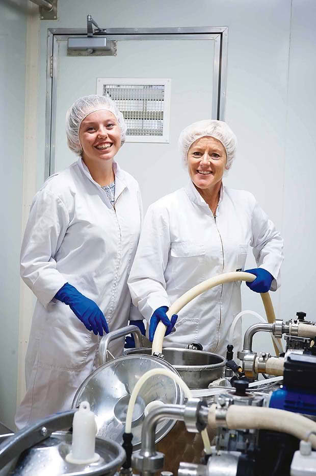  Dairy hand Jessica Armitage helps Mary Vosper fill the vats for the vending machines.