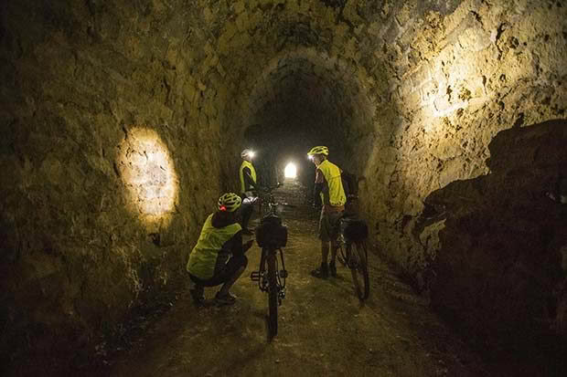 Cyclists follow the trail through the Rakis tunnel on the disused Windsor/Tokarahi railway line.