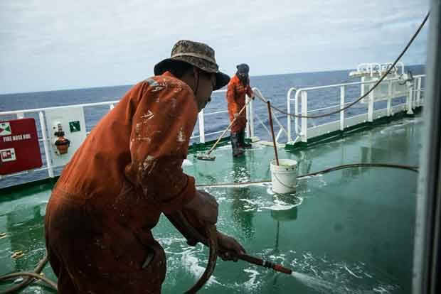 The Spirit of Auckland crew scrub the deck 