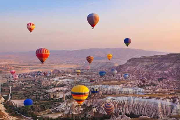 Hot air balloon flying over rock landscape at Cappadocia Turkey. 