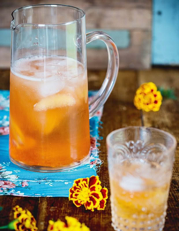 A pitcher containing a grapefruit cocktail. 