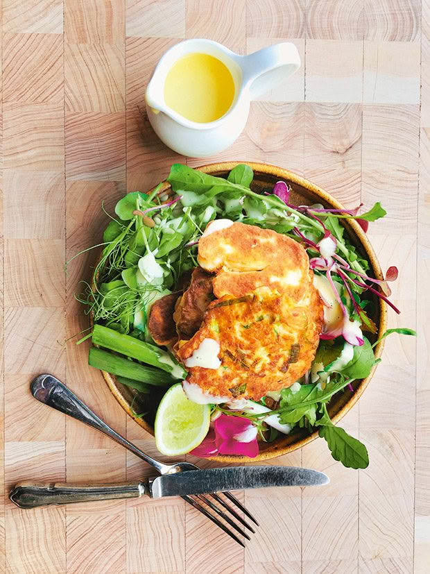 A salad topped with fried halloumi and cauliflower fritters. 