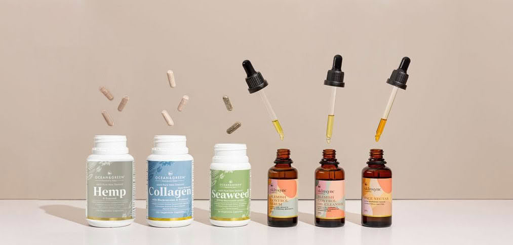 A row of bottles of vitamins and essential oils on a table.