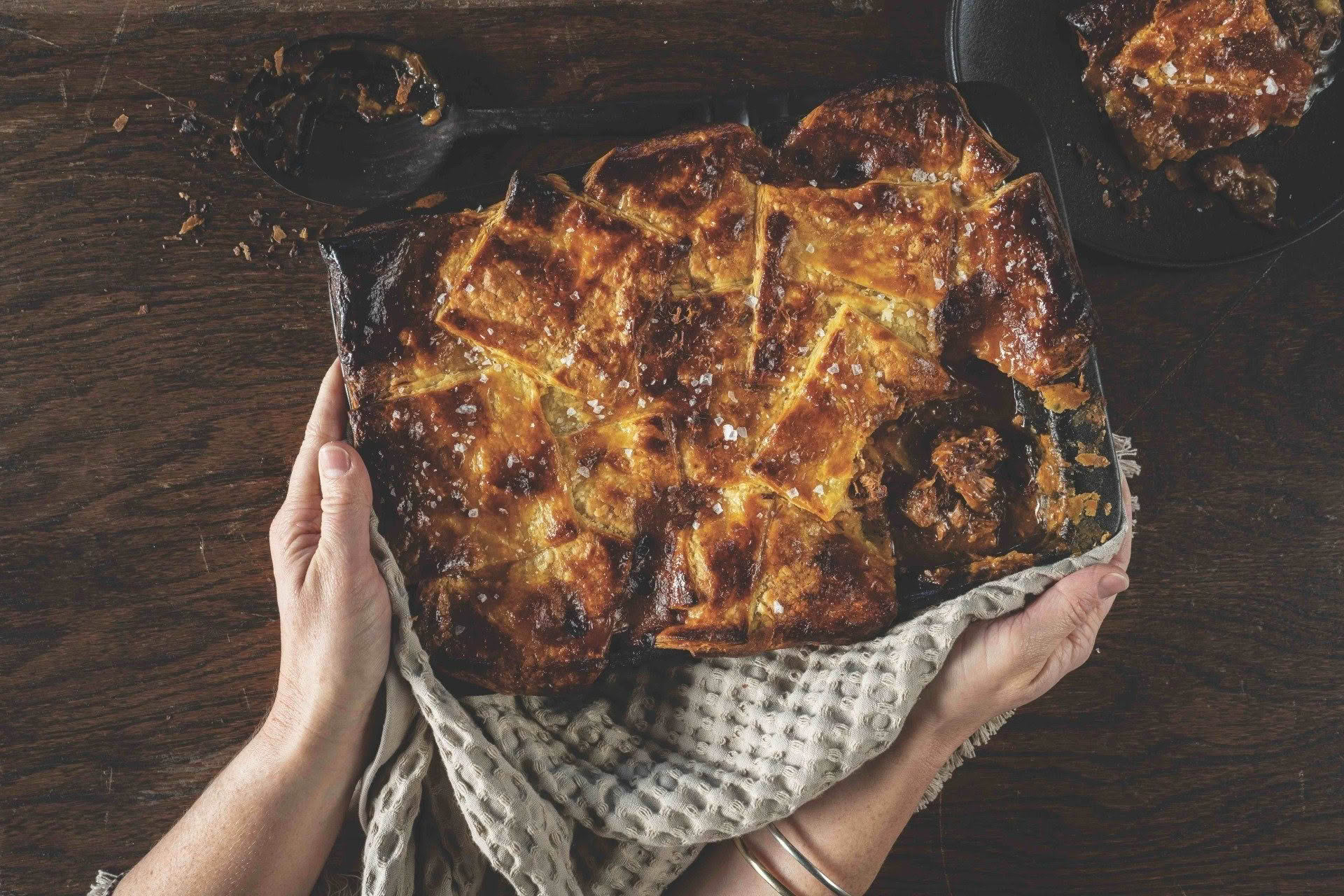 A person is holding a pan of food in their hands.