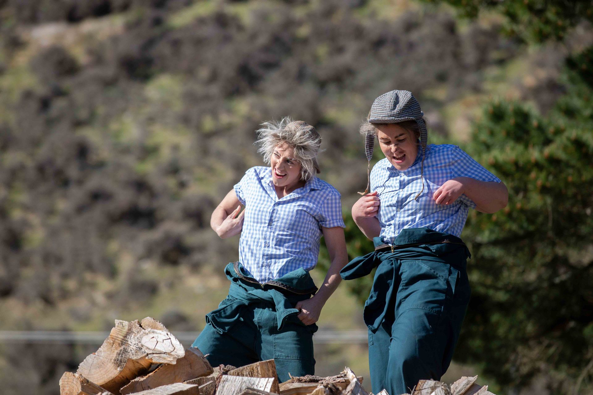 Two women are standing next to each other on top of a pile of rocks.