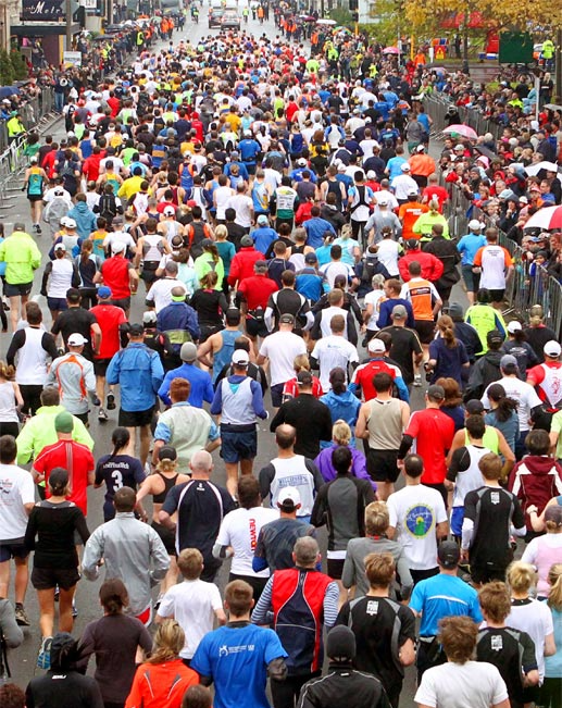 A large crowd of people are running in a marathon