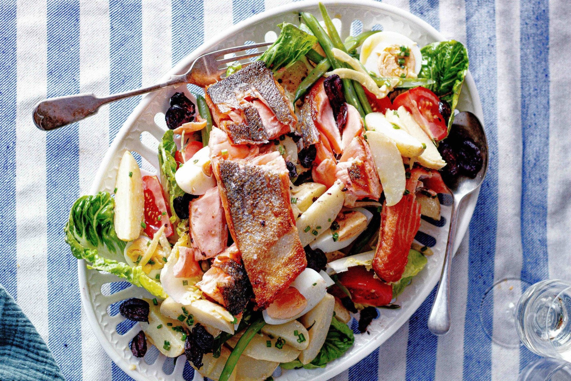 A white plate topped with a salad and a fork