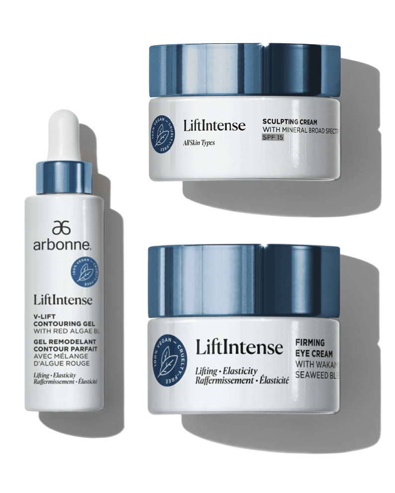 A bottle of lotion , a bottle of serum , and a bottle of cream are sitting on a table.