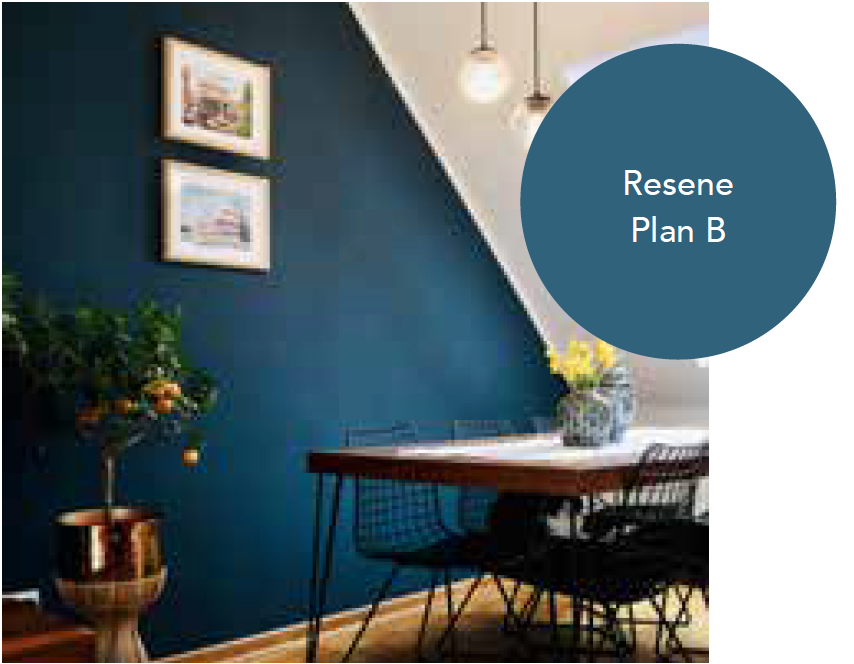 A dining room with a table and chairs and a blue wall.
