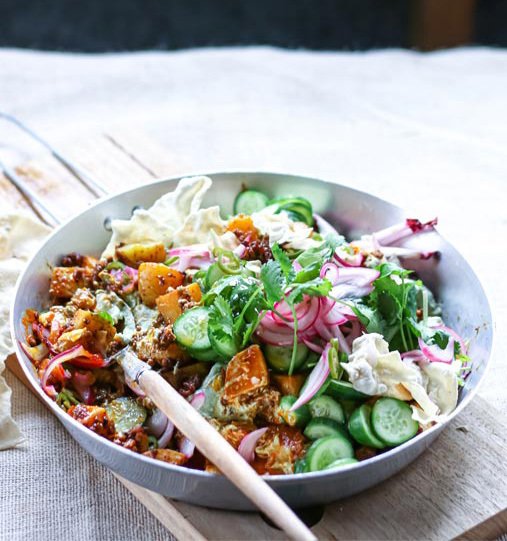 A bowl of vegetables with a wooden spoon in it
